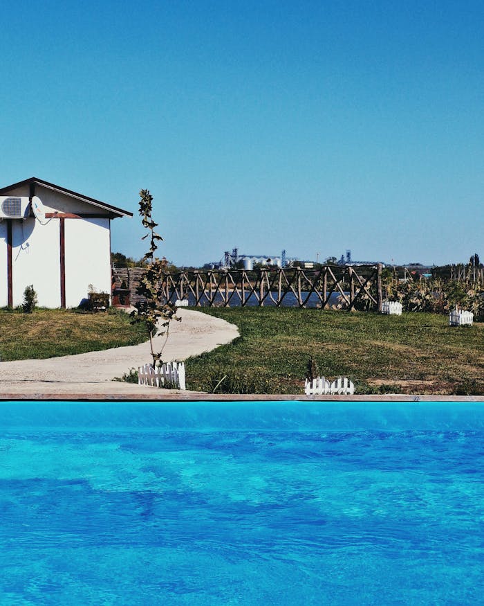 A serene poolside cottage with a scenic background, ideal for relaxation.